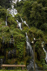Majestic tiered waterfall flowing through a lush tropical rainforest