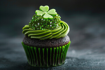 A chocolate cupcake topped with green frosting and a shamrock, decorated for St. Patrick's Day. Selective focus.