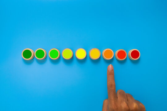 male hand point risk level meter indicator from low to high on wooden blocks. isolated on blue background. concept of risk management