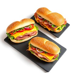 Three sub-style sandwiches with deli meat cheddar cheese lettuce tomato and onion on black trays