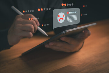 Person using a tablet with digital low rating review and sad feedback icons, representing negative customer experience, online reputation issues, service evaluation, and user dissatisfaction analysis.