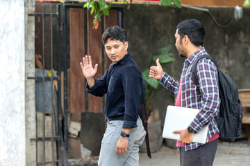 Two Asian men saying goodbye outdoors after work