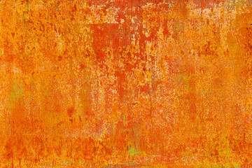 Close-up of a weathered rusty metal surface with a vibrant orange and yellow texture. The corroded iron shows peeling paint and oxidation, creating an abstract industrial background with a rough, aged