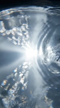 Extreme close up slow motion shot of clear liquid surface rippling and refracting light creating beautiful shimmering abstract illusionary patterns water, organic, reflection