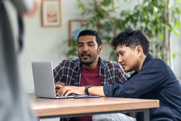Two men working together in an outdoor cafe space