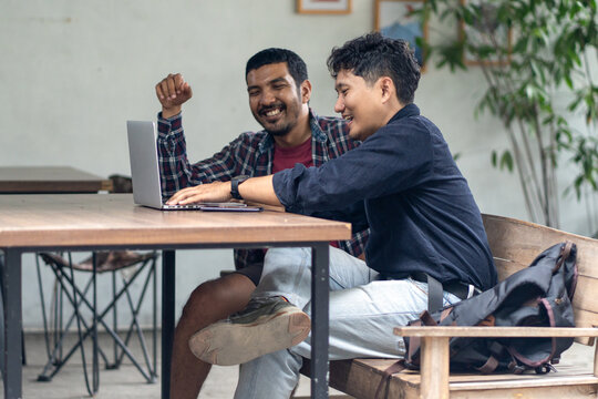 Two men working together in an outdoor cafe space - Powered by Adobe
