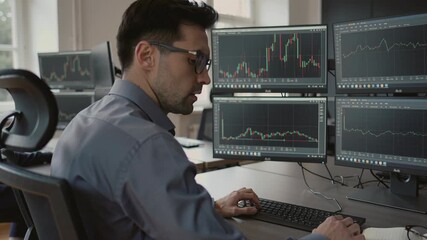 Focused businessman analyzing stock market data on multiple monitors in modern office during daytime, wearing glasses and formal attire, concentrating on financial graphs and trading trends - Powered by Adobe