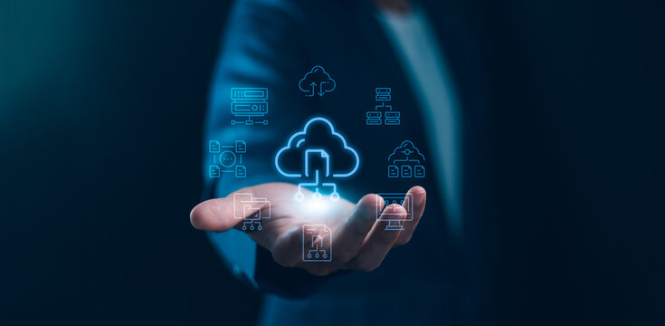 A professional holds futuristic cloud data icons, symbolizing digital network storage, modern business computing, infrastructure management, security, and global technology transformation.