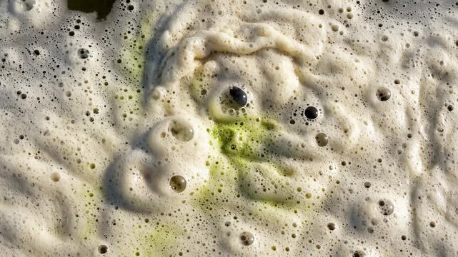Close Up of Thick Dirty Foam Moving on Water Surface in Slow Motion