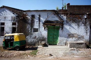 'Work - Home' Balance - A Private rickshaw Parked in front of a Traditionally built large house.