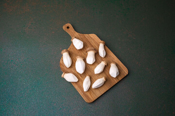 Raw king oyster mushrooms arranged on wooden cutting board for fresh vegetable or natural product background