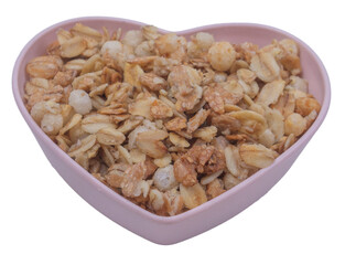 Isolated heart-shaped saucer with granola on a white background, side view, copy space