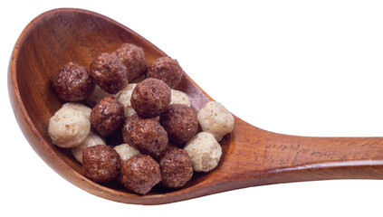 Isolated wooden spoon with corn balls on a white background, side view