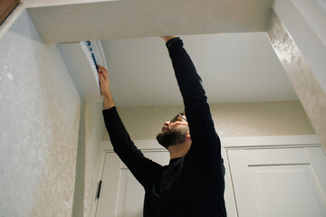 Man installing trim above doorway in a home on a weekend afternoon for a renovation project