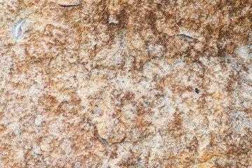 Close-up of brown rocky surface with rough texture, geology, natural background.