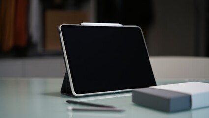 Tablet in protective case with stylus foreground on a clean studio desk setup