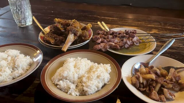 Diners savoring delicious Sate Klatak and traditional Indonesian dishes at a Yogyakarta restaurant