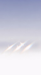 Minimalist abstract background featuring a soft, fading pastel gradient from light blue to white, with striking, blurred prismatic light streaks near the bottom. Ideal for clean design.