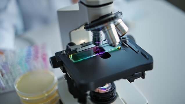 Close-up of a microscope turret with prepared samples on a lab bench today.