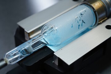 Close-up frost-coated glass tube glistens within precision laboratory equipment