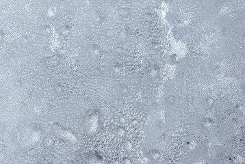 A frosty window with water droplets on it