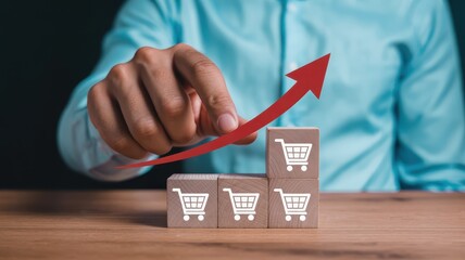 Business person manipulates rising sales trend indicated by shopping cart icons stacked on wooden blocks