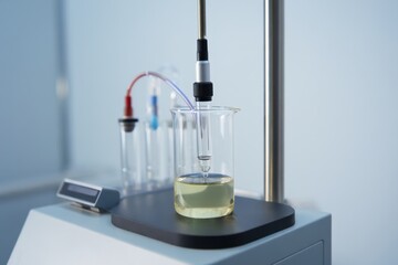 Laboratory beaker setup with tubing and precision instrument in bench-top rig
