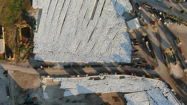 Aerial view (drone) of massive stacks of packaged sugar beet pulp for animal feed at a sugar factory.