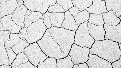 Cracked earth texture, illustrating drought and aridity. The intricate pattern of cracks create a...