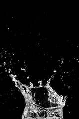 A captivating water splash against a dark background, the image captures the dynamic moment of impact, with droplets of water scattered