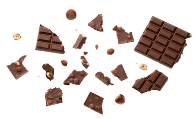 Scattered pieces of nut chocolate with whole hazelnuts isolated top view, perfect for confectionery advertising, dessert branding, packaging design and gourmet sweet food concepts