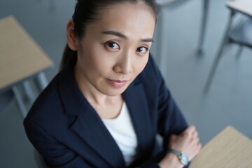 Educator in business casual attire faces camera with a confident, fully frontal gaze