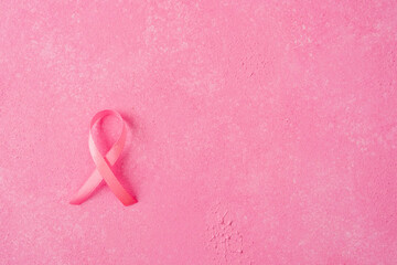 Pink breast cancer ribbon symbol on solid pink background