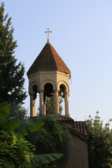 Dome with Cross of The Traditional Georgian Orthodox Church Bell Tower  with Blue  sky Background and Leaves by it in Tbilisi, Georgia