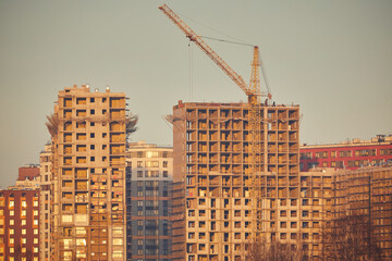 A close-up of a multi-story building under construction in sunset colors