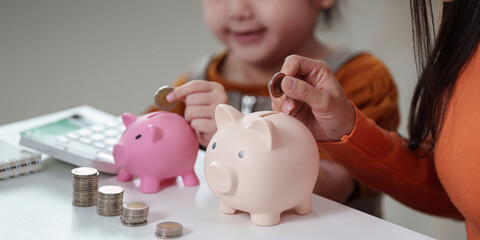 Teaching Saving. Child and parent using piggy banks for financial education.