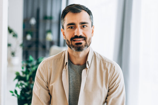 Middle-aged bearded man smiling confidently thoughtful and relaxed indoors