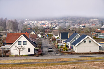 Car drive on a street in a residential area with detached houses a frosty spring day