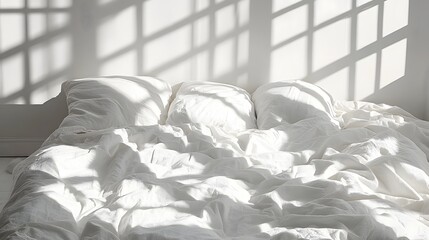 Unmade white bedding receives strong geometric sunlight patterns cast from a nearby window