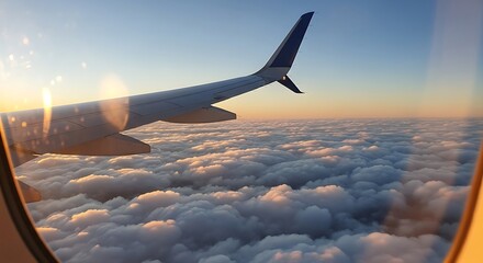 Airplane wing and clouds seen from a window during a beautiful sunrise