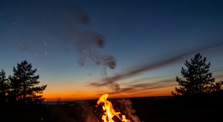 Campfire glows against a twilight sky with silhouetted pine trees