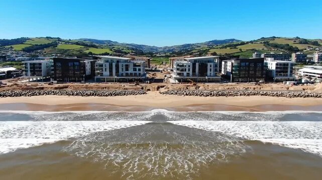 Beachfront construction development aerial view ocean waves sand landscape building site progress