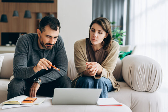 Couple planning finances together at home sitting on couch