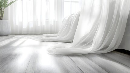 Bright natural light streams across sheer white drapery pooling onto light wooden flooring