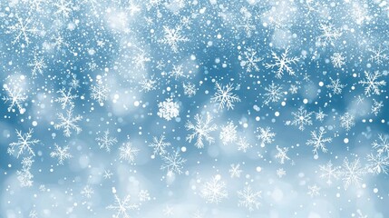 Fototapeta premium Light blue winter background featuring blurred white snowflakes.