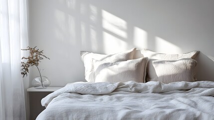 Bright morning light illuminates neatly made bed with natural textile bedding beside sheer window covering