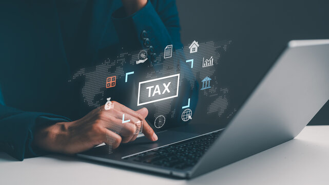 A person is using a laptop to manage tax-related information, with digital icons and a world map displayed, symbolizing online financial management.