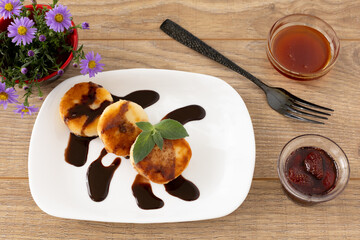 Curd fritters with chocolate, strawberry jam and honey.