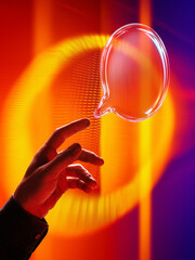 Hand touching glowing glass speech bubble in bright neon interface room. Concept of communication...