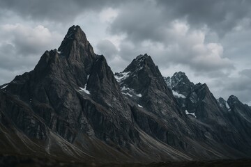 Dramatic jagged mountain peaks under overcast sky with snow patches on rocky slopes in moody wilderness landscape concept scene. Ai generative
